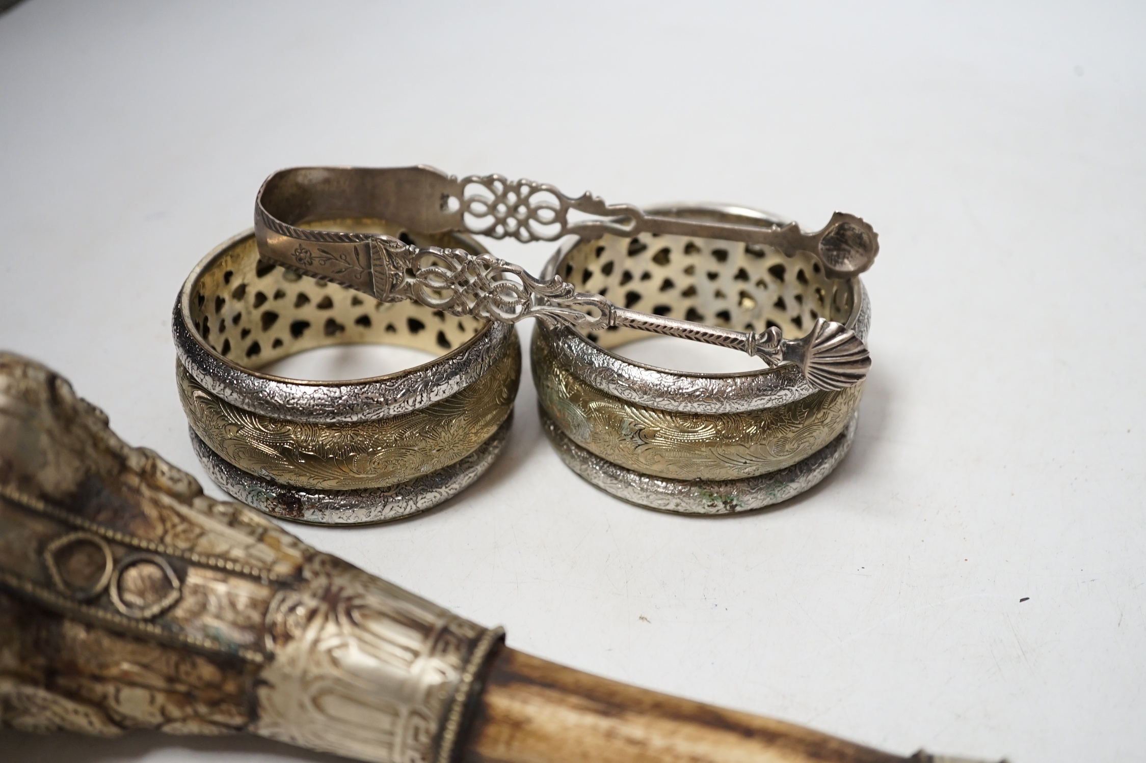 A pair of Georgian silver sugar tongs, a mounted bone implement and a pair of mixed metal bangles.